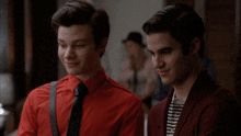 two men in red shirts and ties are standing next to each other and smiling