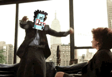 a man in a suit is dancing in front of a woman in front of a window with the empire state building in the background