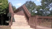 a wooden deck with stairs leading up to a house