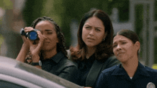 three police officers are looking through binoculars and one has a badge that says l.a.p.d.