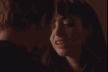 a man and woman are kissing each other in a dark room .
