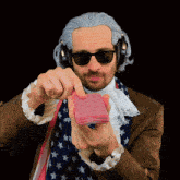 a man in a wig and sunglasses is holding a stack of cards