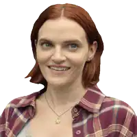 a woman with red hair and a plaid shirt is smiling