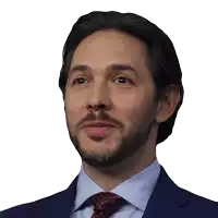 a man with a beard is wearing a blue suit and red tie