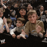 a boy wearing a shirt that says rock 'n ' roll is clapping in a crowd