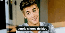 justin bieber is smiling and talking in spanish while sitting on a couch in a living room .