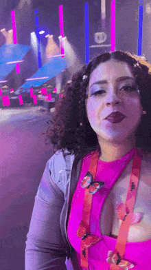 a woman wearing a pink top and a lanyard with butterflies on it