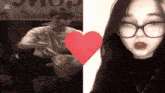 a man and a woman standing next to each other with a red heart in the middle