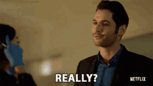 a man in a suit is smiling and says really