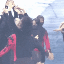 a blurry picture of a group of people with their arms in the air
