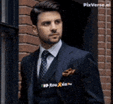 a man wearing a suit and tie with rou ka written on his pocket square