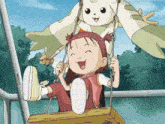a little girl is sitting on a swing with a bunny on her head