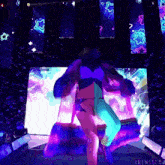 a woman is dancing in front of a screen that says tringglow on it