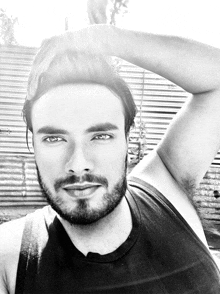 a black and white photo of a man with a beard and a black tank top