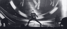 a man is dancing on a stage in front of a crowd .