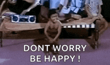 a group of people are sitting on a couch with the words `` dont worry be happy '' written above them .