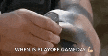 a person is holding a watch on their wrist and the words `` when is playoff gameday '' are visible .