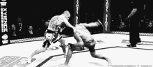 a black and white photo of two men fighting in a ring that says bud light on the corner