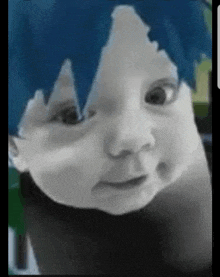 a close up of a baby 's face with blue hair