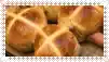a close up of a bunch of hot cross buns on a wooden table .