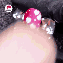 a close up of a person 's nails with a red nail with white dots