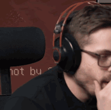 a man wearing headphones is sitting in front of a wall that says not by