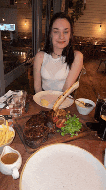a woman sits at a table with a plate of food