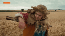 a scarecrow in a field with kayak written on the bottom