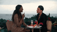 a man and a woman are sitting at a table with glasses of champagne