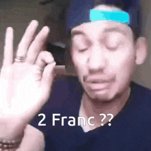 a man wearing a hat is making a funny face and says 2 franc ?