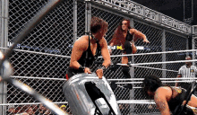 two women are wrestling in a ring with a trash can in the corner