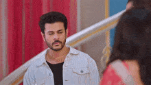 a man with a beard is standing in front of a woman