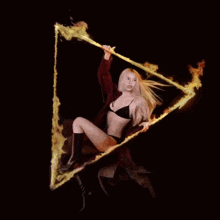 a woman in a bikini is holding a triangle of fire