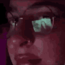 a close up of a person wearing glasses with a reflection of a phone in them .