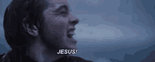 a close up of a man screaming in the rain and saying jesus .