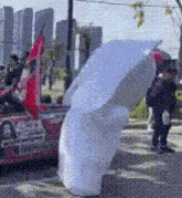 a person holding a white umbrella in a blurry photo