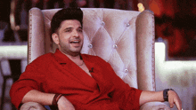 a man wearing a red shirt is sitting in a chair