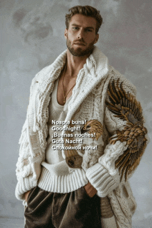a man wearing a white sweater with wings on the sleeves says noapte buna