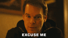 a close up of a man 's face with the words excuse me behind him