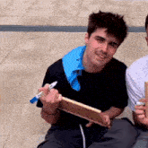 a man is holding a piece of wood and a marker