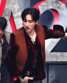 a man is dancing in front of a kbs sign