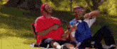 two men are having a picnic in the park and one of them is holding a gun .