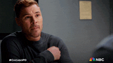 a man sitting in a room with a chicagopd logo on the bottom right