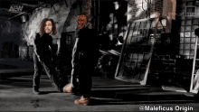 a man in a mask is standing next to another man in a dark room with a aew logo on the wall