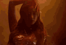 a woman with long red hair is standing in a dark room