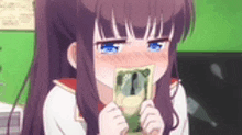 a girl with long purple hair is holding a piece of money in her mouth .