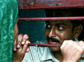 a man with a mustache is behind a red railing