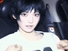 a young woman with short black hair is sitting in a chair in a movie theater .