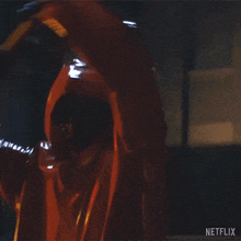 a close up of a person in a red raincoat with netflix written on the bottom