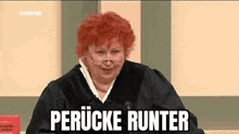 a judge with red hair and glasses is sitting in front of a microphone and a book .